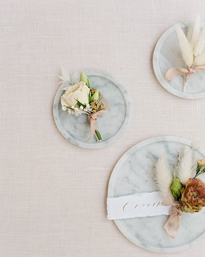 Three boutonnieres on marble trays