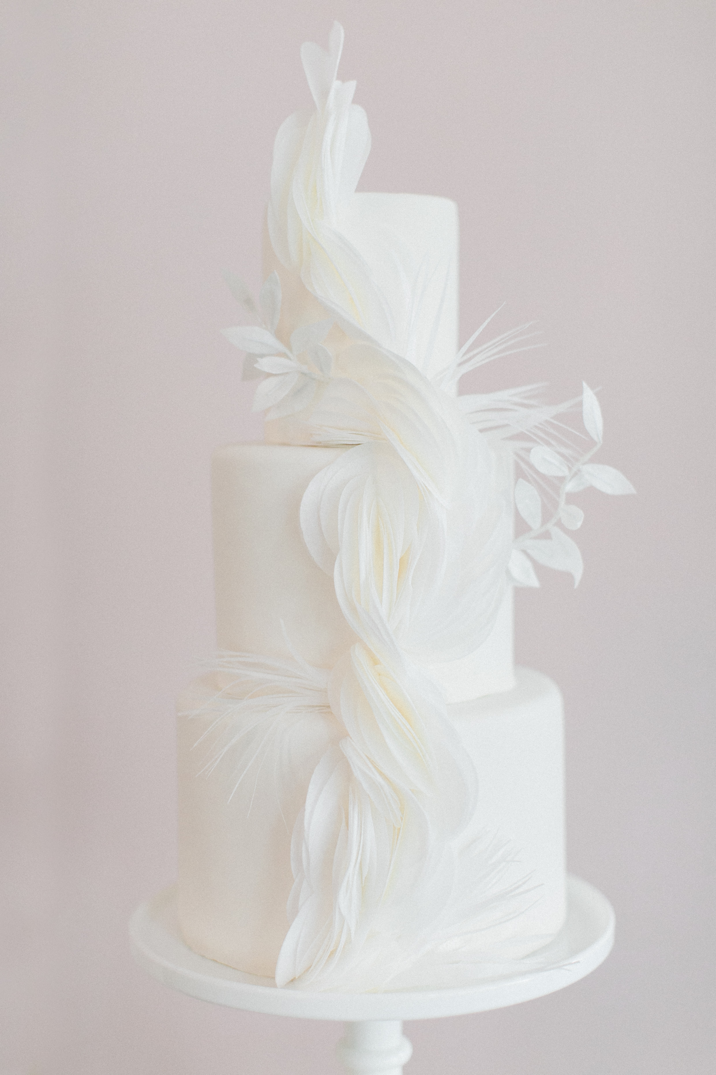 White, three tiered wedding cake with sugar paper detail