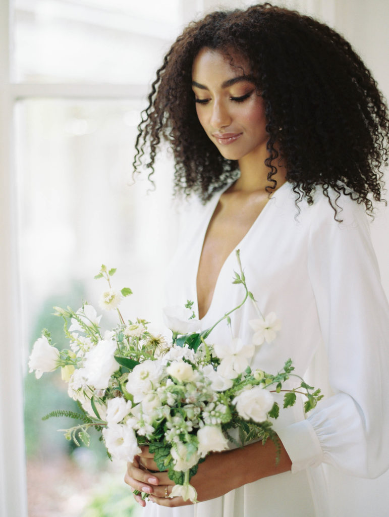 Bride with all white bouquet and long-sleeved wedding gown